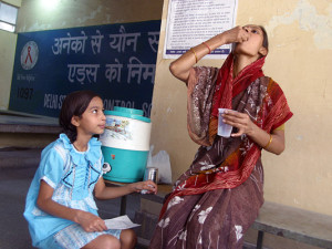 A child watches as her mother takes her TB medications (DOTS) © WHO/TBP/Gary Hampton