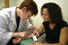 A health care worker measures the size of the reaction to the tuberculin skin test © CDC
